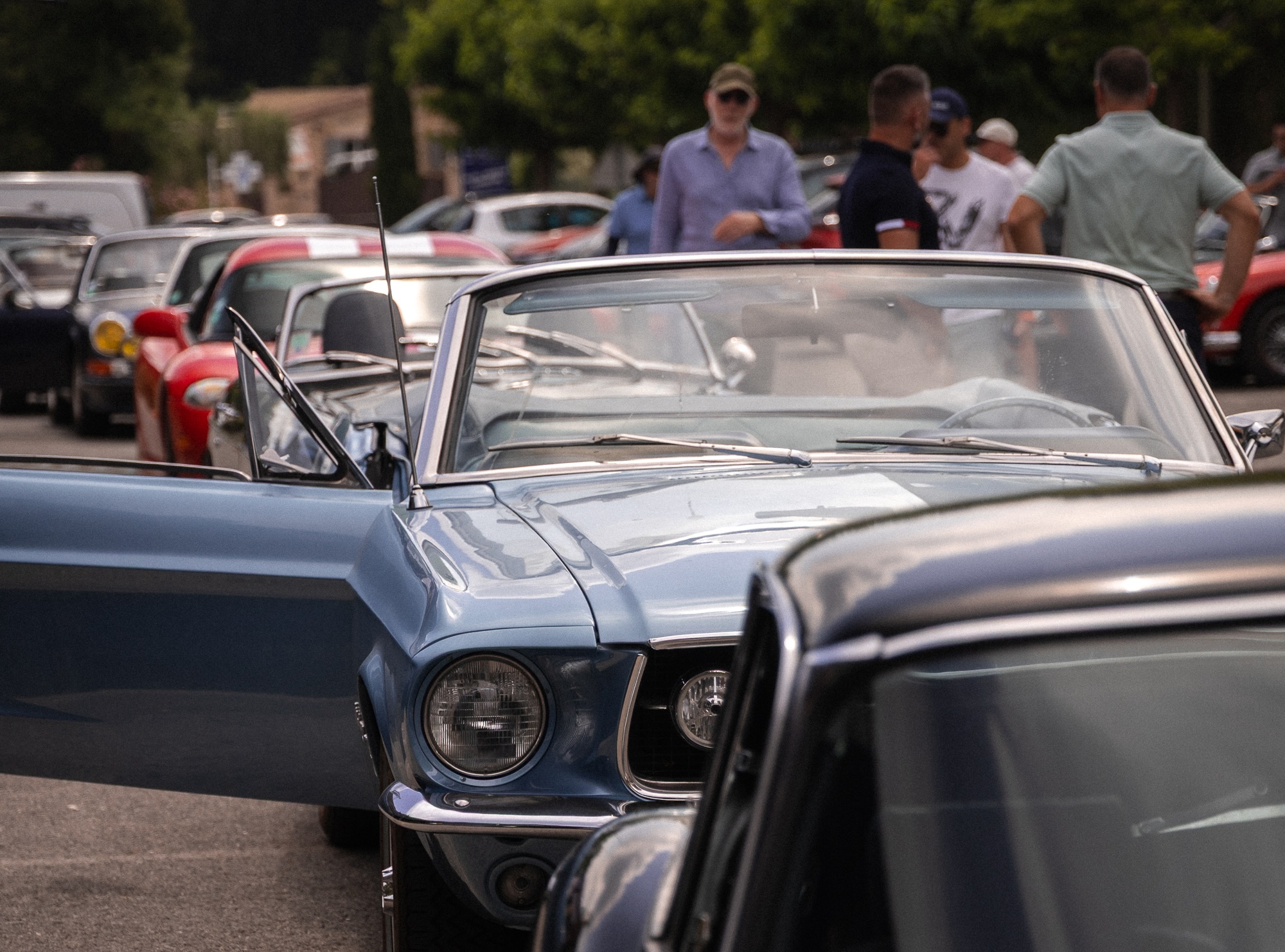 Guests gathering around classic cars during an incentive event